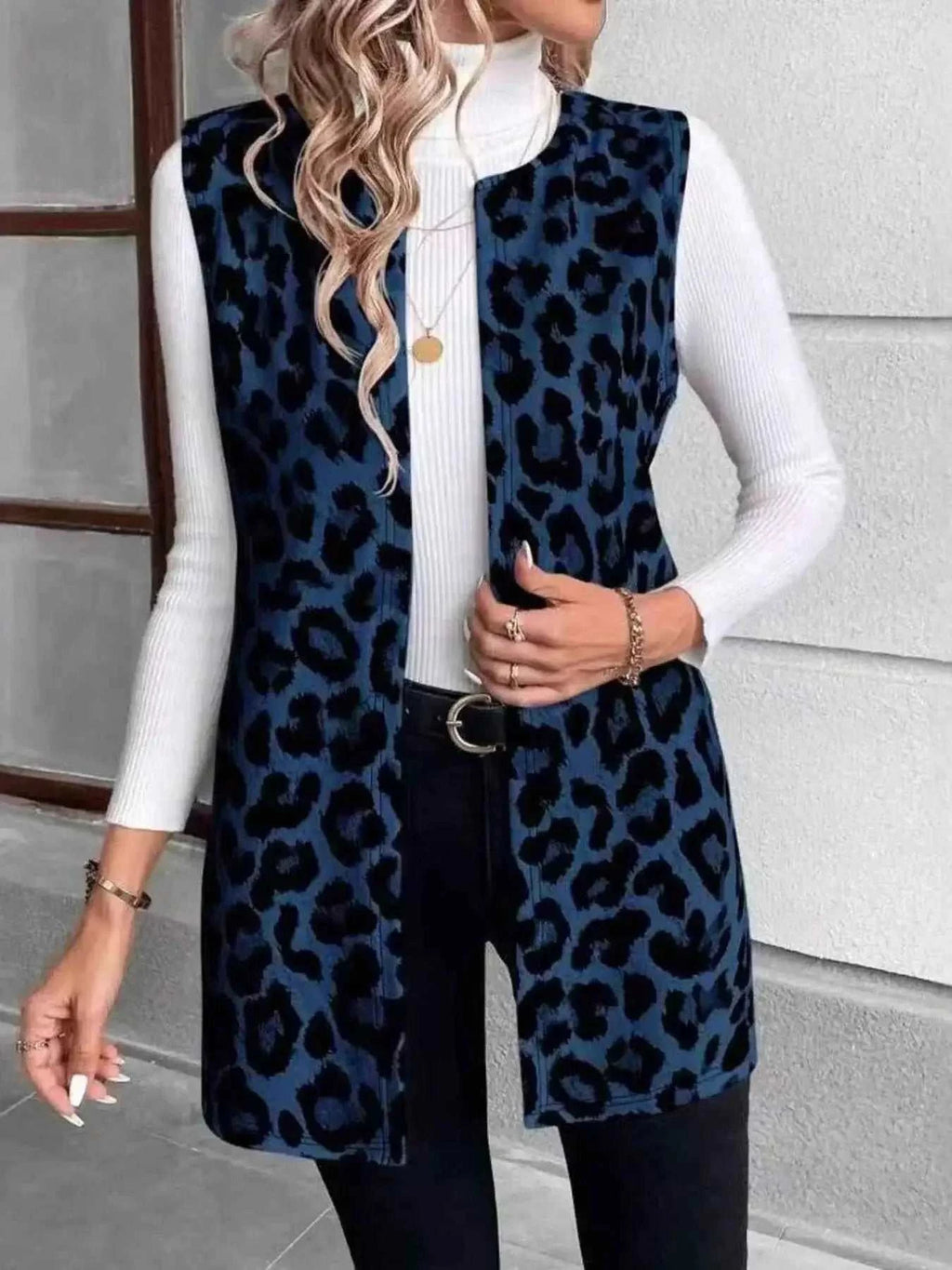 Sleeveless Leopard Print Vest in dark blue and black leopard pattern with pockets worn over a white turtleneck