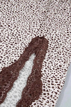 Slit Animal Print Skirt featuring brown lace detail and small irregular brown spots on white fabric with a front split