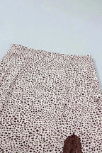 Slit Animal Print Skirt featuring beige background with brown leopard spots and a lace detail slit on a polyester blend fabric