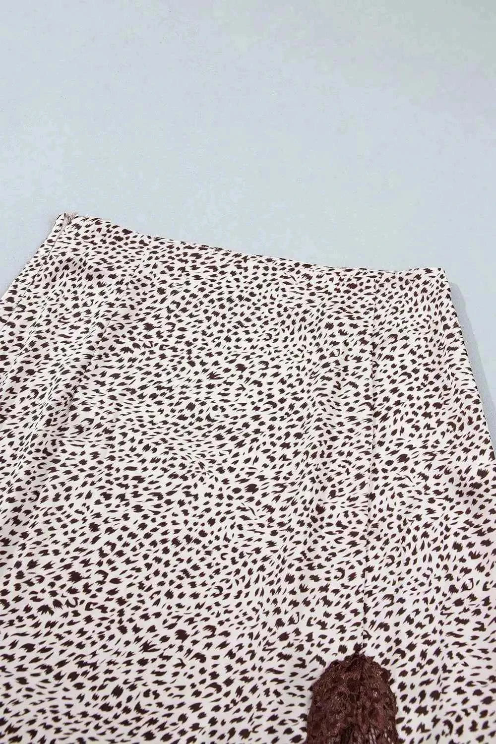 Slit Animal Print Skirt featuring beige background with brown leopard spots and a lace detail slit on a polyester blend fabric