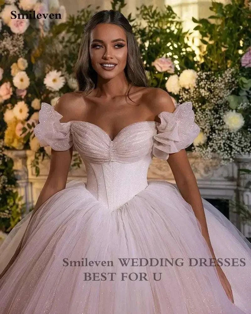Smileven Princess Wedding Dress in blush pink with corset sweetheart neckline, off-shoulder puff sleeves and glitter tulle ball gown skirt
