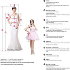 Two women modeling strapless V-neck wedding dresses in white and light pink with lace and floral appliques, floor-length and sleeveless styles