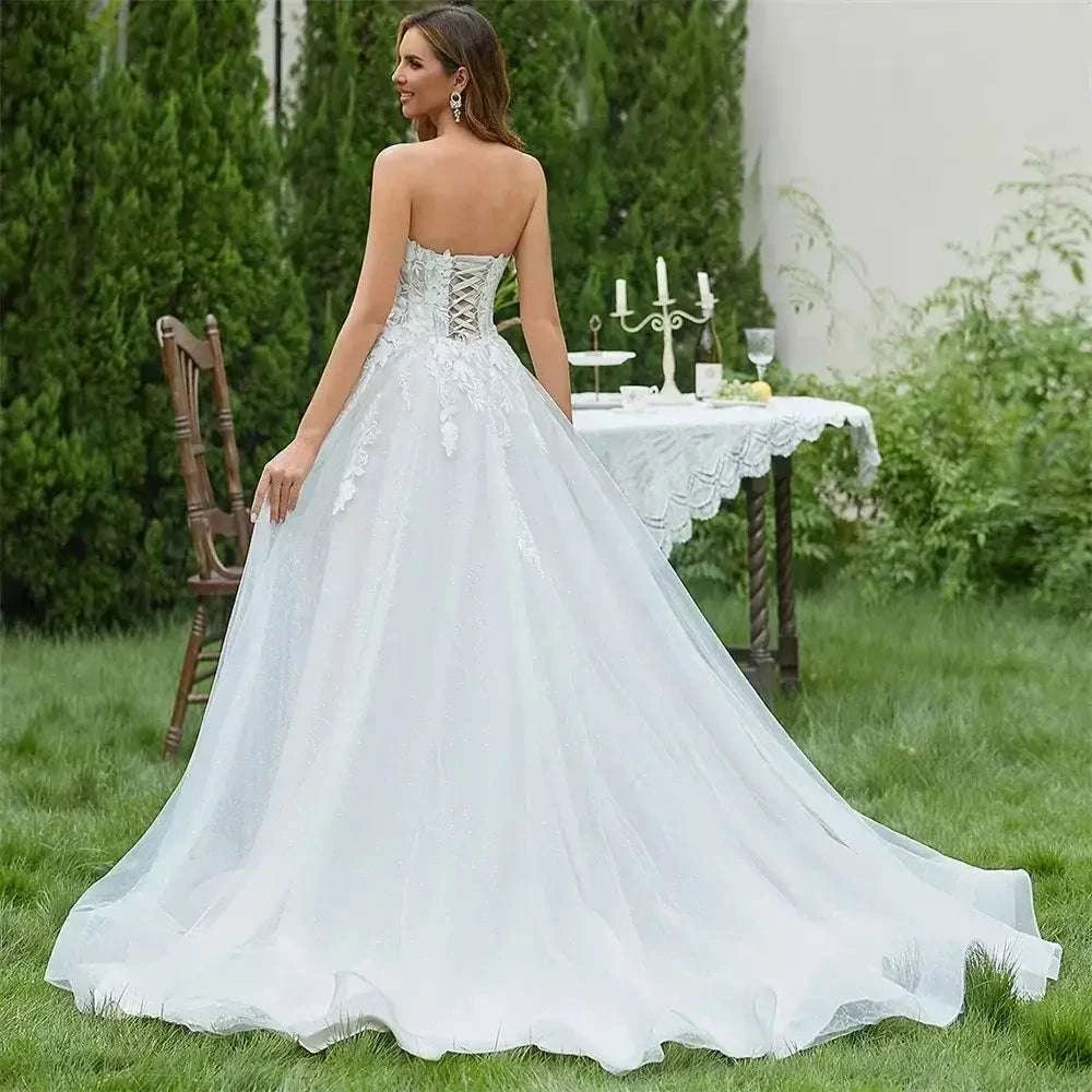 Strapless V-neck white A-line wedding dress with lace-up back and 3D flower lace applique detailing and a long sweep train