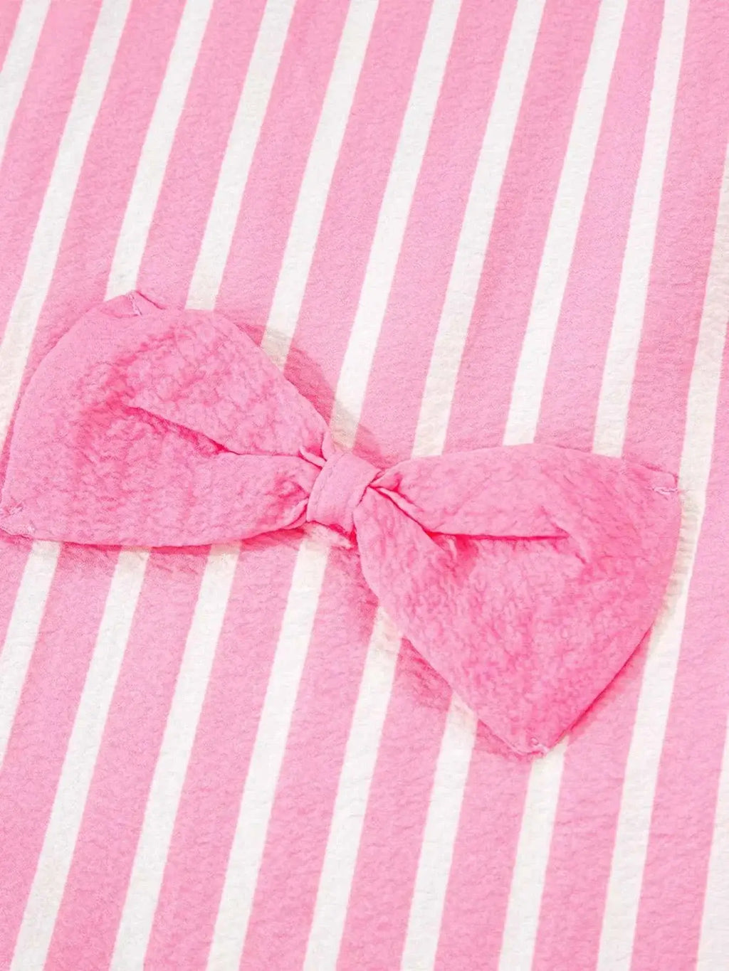 Stripe Buttoned Front pink and white striped fabric with a textured pink bow detail on soft polyester material