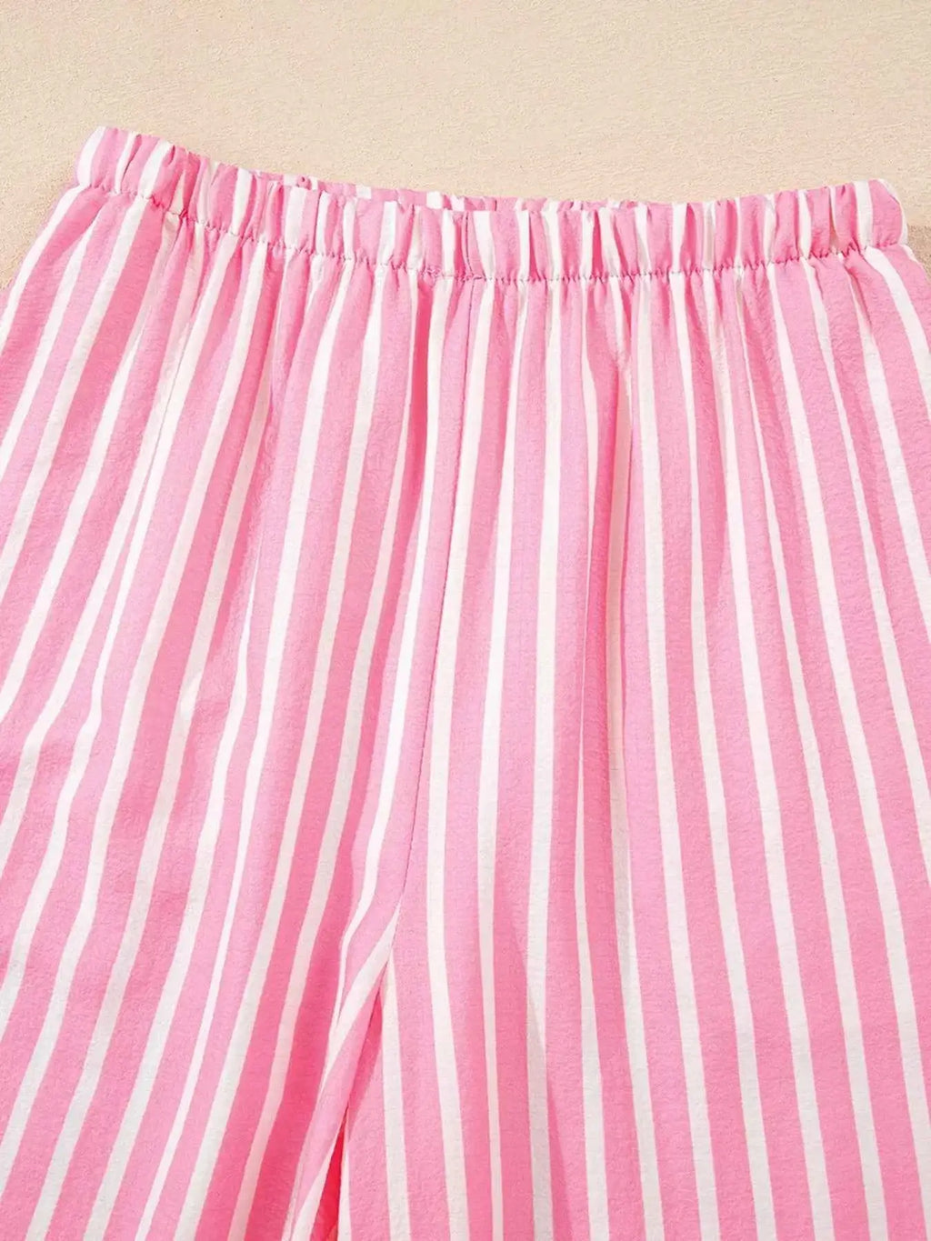 Stripe Buttoned Front pink and white vertical striped pants with elastic waistband made of polyester fabric