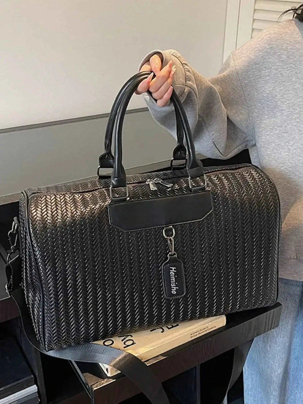 Textured Leather Travel Bag in black PU leather with a braided pattern, dual handles, and a detachable shoulder strap