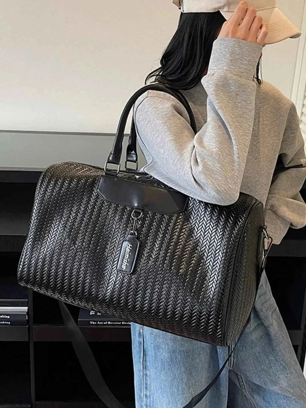 Textured Leather Travel Bag in black PU leather with a woven pattern, featuring handles and a detachable shoulder strap