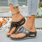 Toe Post Wedge Sandals in black PU leather with crocodile pattern and decorative metal detail on mid heel platform