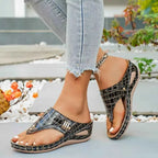 Toe Post Wedge Sandals in black faux crocodile PU leather with mid heel and open toe design worn with ankle bracelet