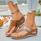 Brown PU leather toe post wedge sandals with a crocodile pattern and ankle chain accessory on model feet wearing light blue jeans