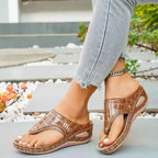 Brown croc-patterned Toe Post Wedge Sandals with mid heels and PU leather material worn with light denim jeans