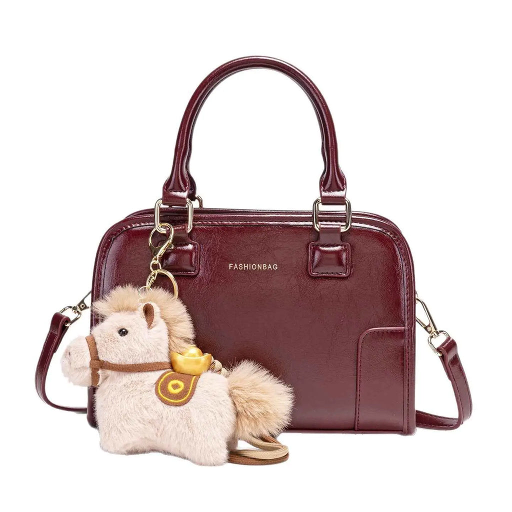 Vintage Style Barrel Crossbody Bag in burgundy PU leather with double handles and a small plush horse charm attached