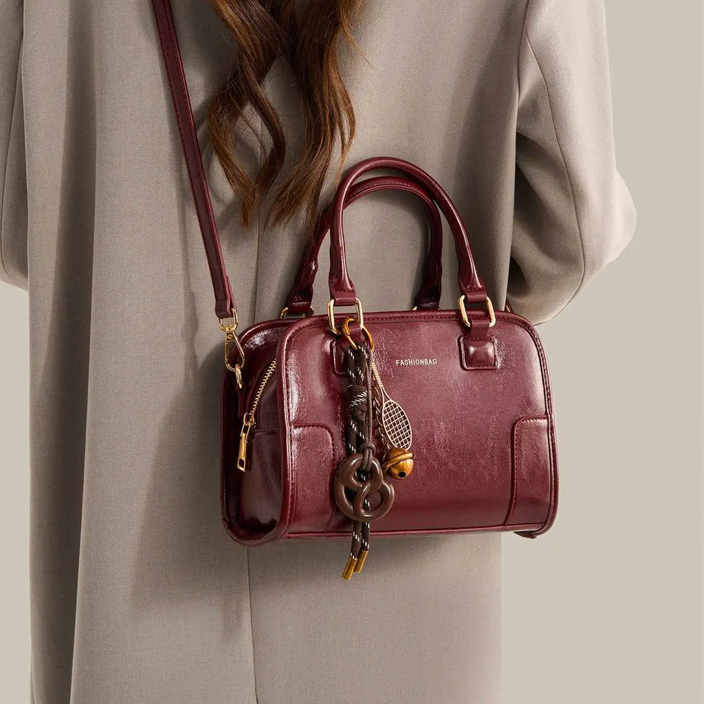 Vintage Style Barrel Crossbody Bag in glossy burgundy PU leather with gold hardware and decorative keychain charm