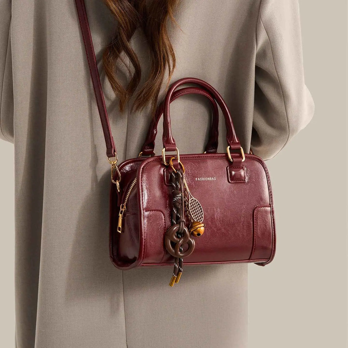 Vintage Style Barrel Crossbody Bag in glossy burgundy PU leather with gold hardware and decorative keychain charm