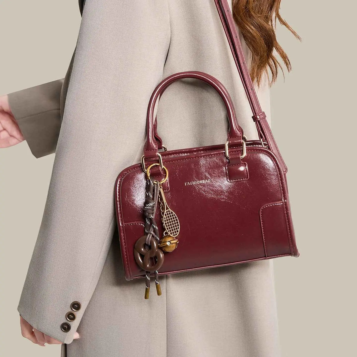 Vintage Style Barrel Crossbody Bag in glossy dark red PU leather with dual handles and decorative hanging charms