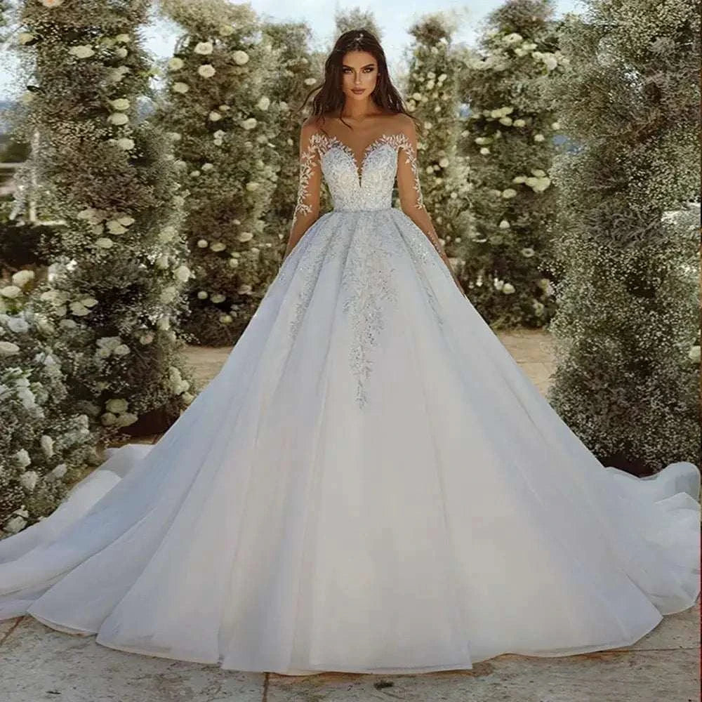 Wedding Dresses white ball gown with sweetheart neckline, lace appliques, sheer long sleeves, and tiered tulle skirt