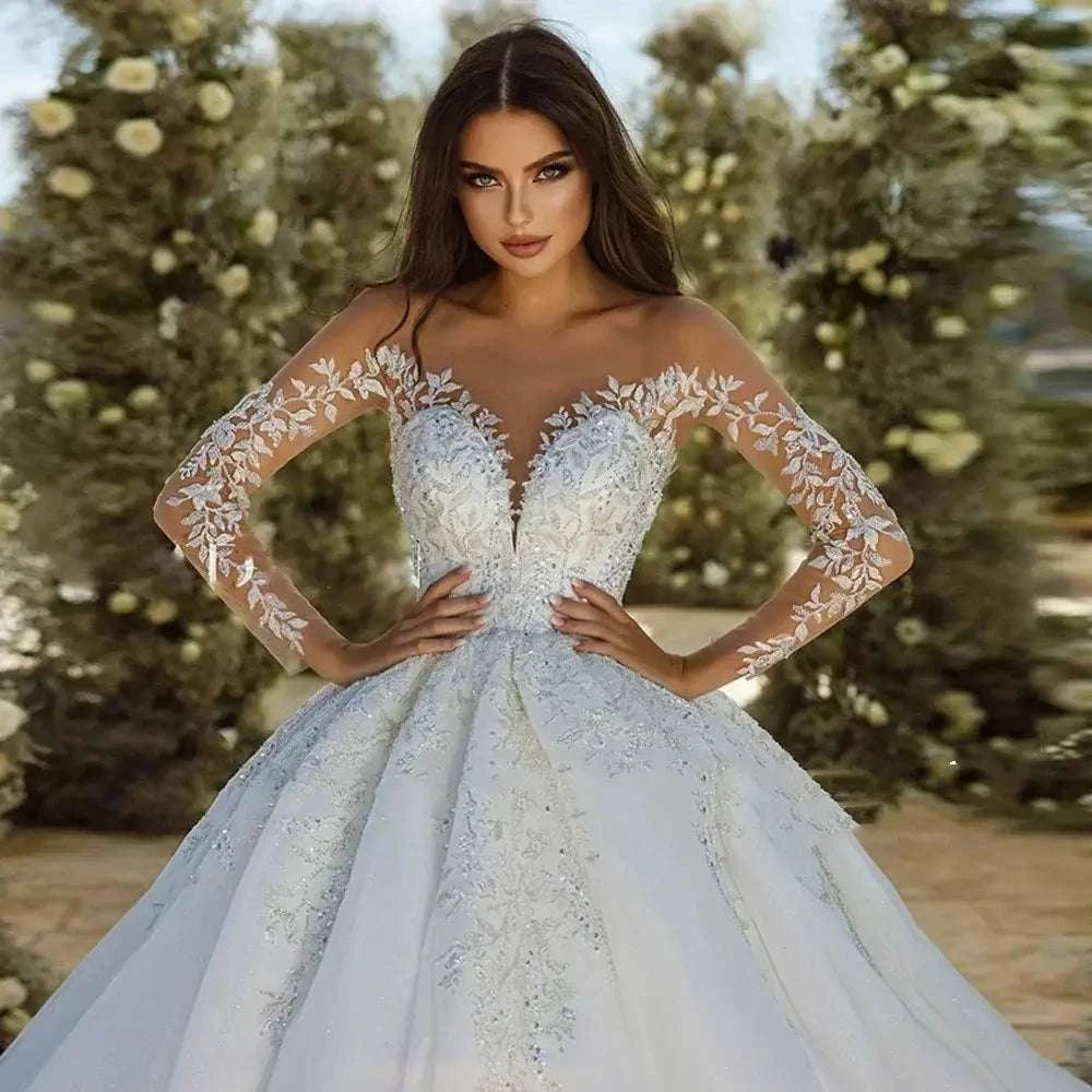 Wedding Dresses white ball gown style with sheer long sleeves, floral lace appliques, and a deep sweetheart neckline