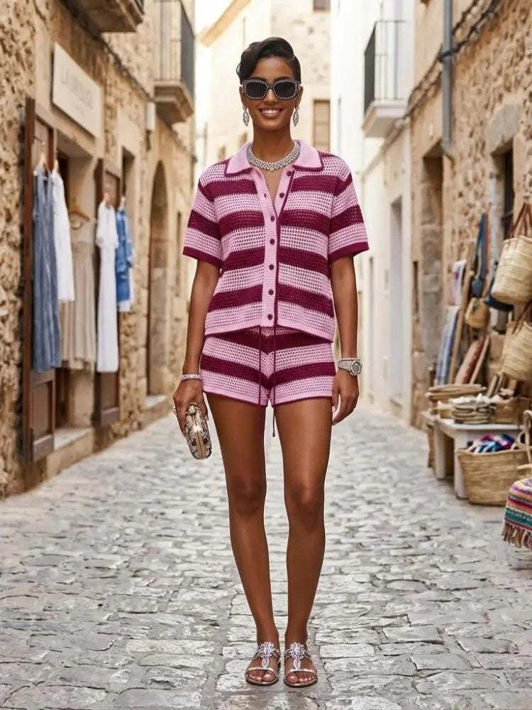 A woman wearing a pink and maroon striped knitted short-sleeved button-up top with matching shorts from BYMANYC New York