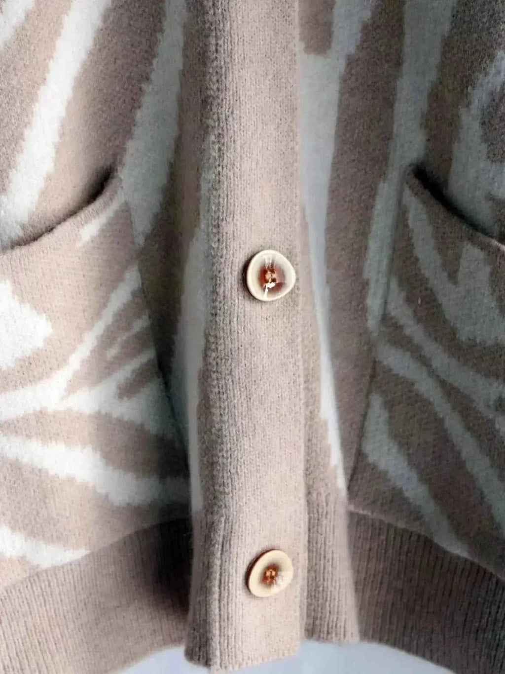 Zebra Print Button Up cardigan in beige and white with buttoned front and front pockets made of soft knit material
