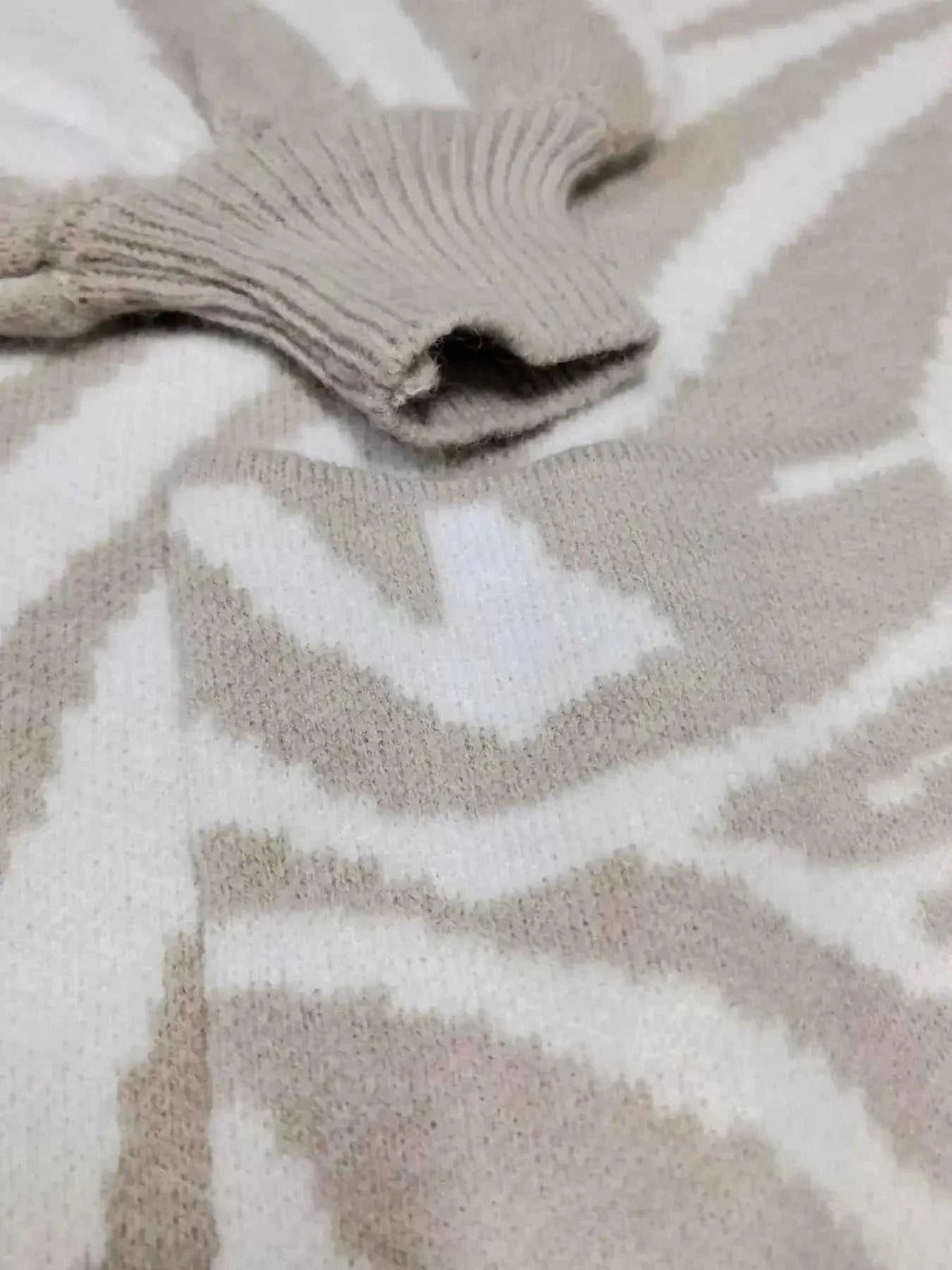 Zebra Print Button Up cardigan with beige and white zebra stripes, soft knit texture, and ribbed cuff detail