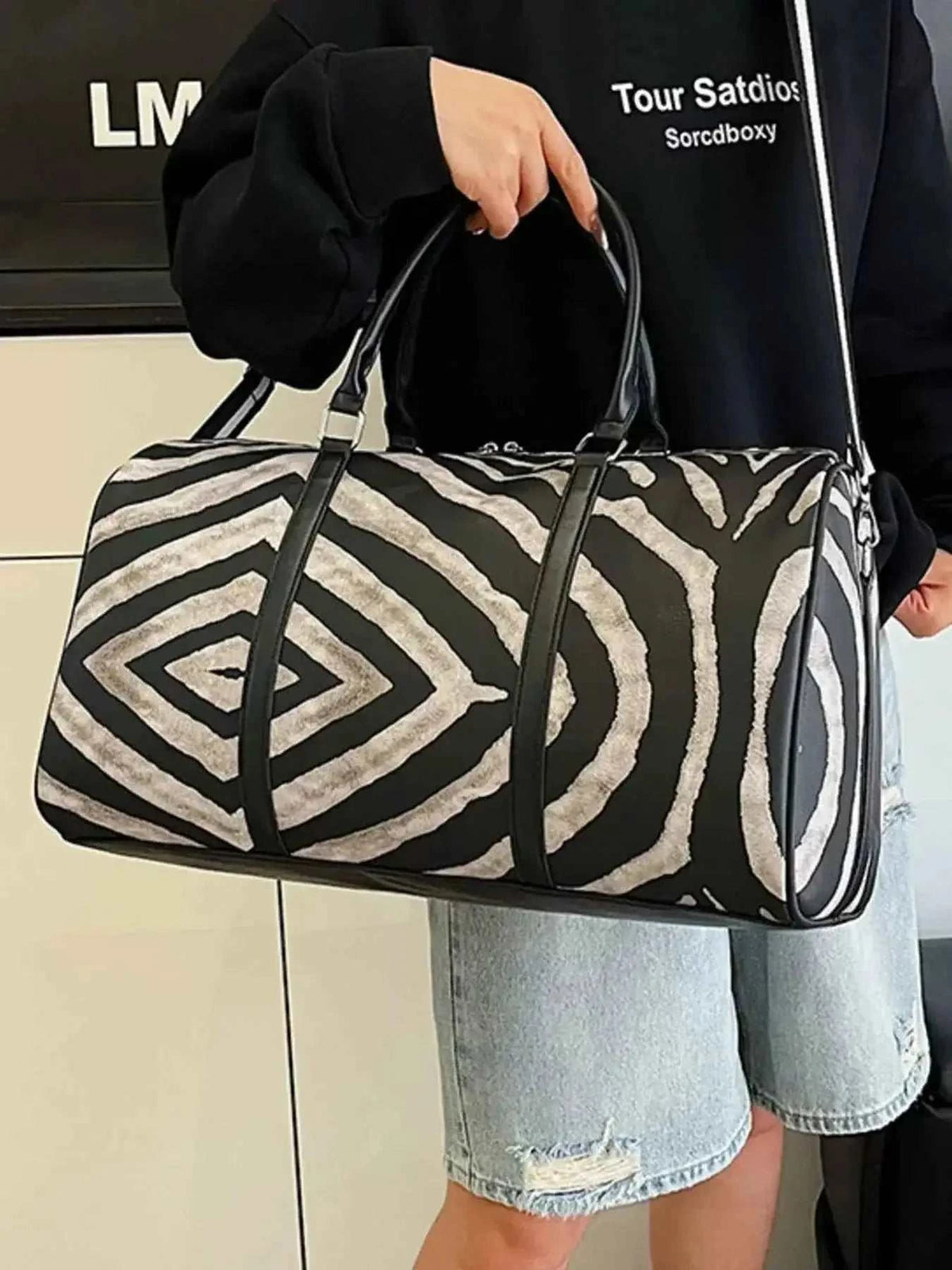 Zebra Print Duffle Bag in black and white PU leather with bold geometric zebra stripes and black handles, large size