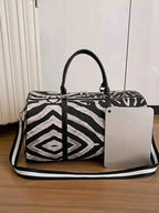 Large Zebra Print Duffle Bag in black and white PU leather with dual handles and an adjustable shoulder strap