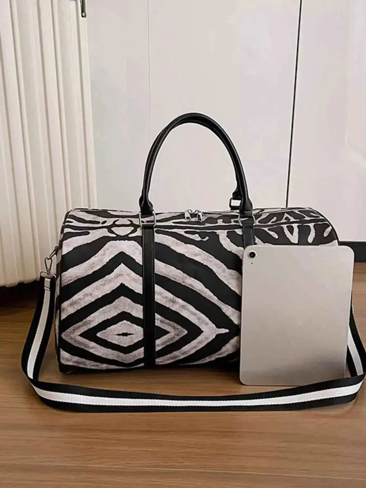 Large Zebra Print Duffle Bag in black and white PU leather with dual handles and an adjustable shoulder strap