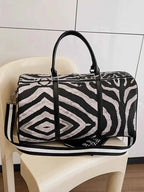 Zebra Print Duffle Bag in black and white PU leather with bold zebra pattern, dual handles, and a striped shoulder strap