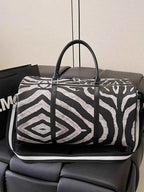 Large Zebra Print Duffle Bag in black and white PU leather with bold abstract zebra pattern and black handles