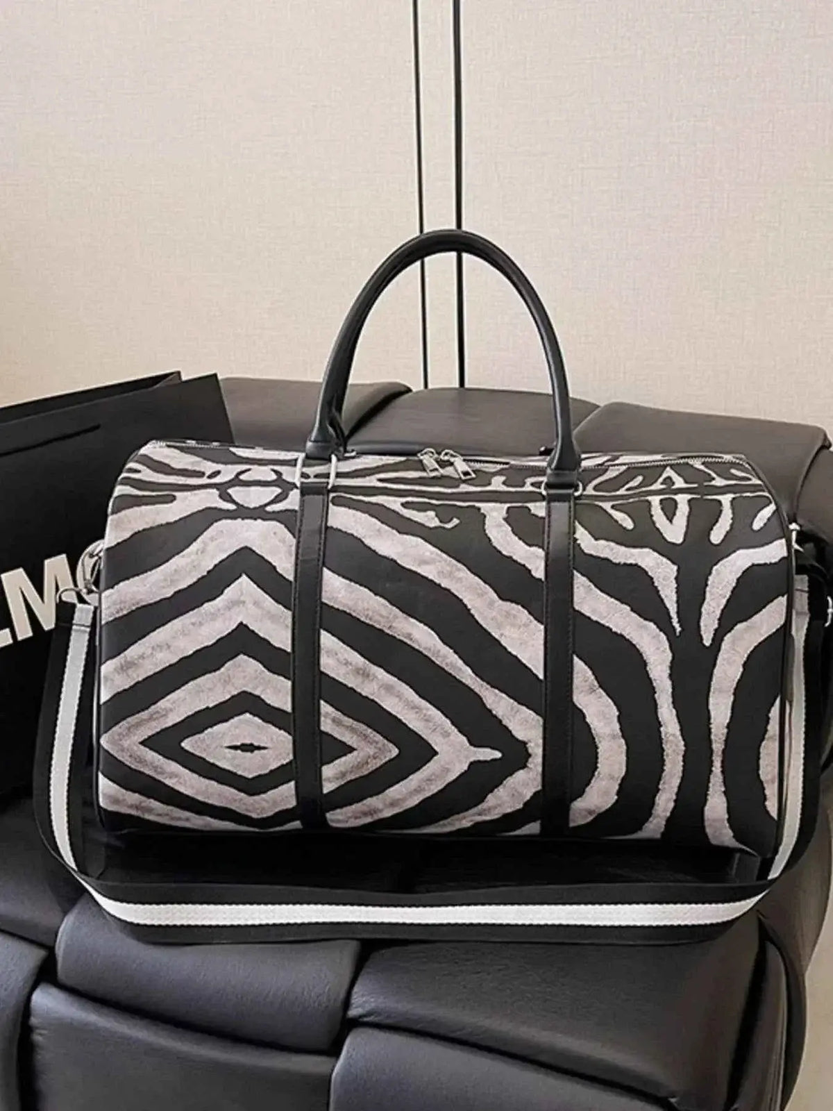 Large Zebra Print Duffle Bag in black and white PU leather with bold abstract zebra pattern and black handles