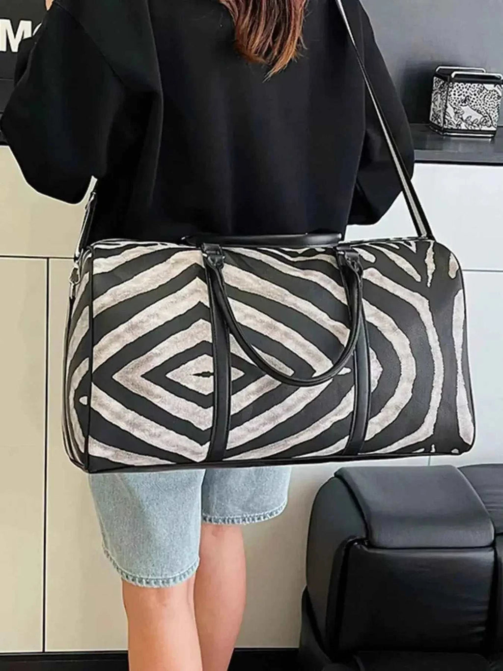 Large zebra print duffle bag in black and white PU leather with shoulder strap and handles, perfect for travel