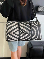 Large zebra print duffle bag in black and white PU leather with shoulder strap and handles, perfect for travel