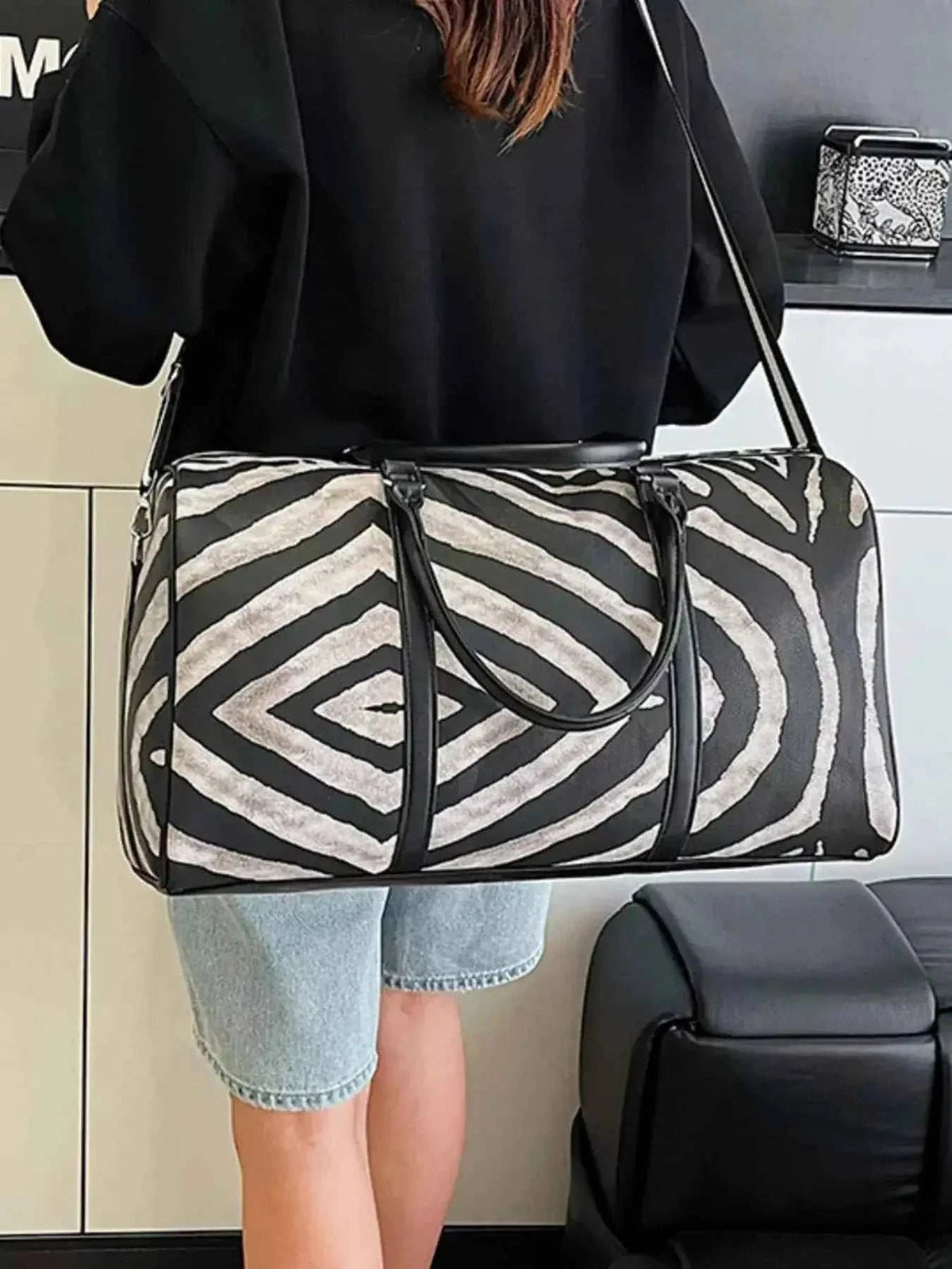 Large zebra print duffle bag in black and white PU leather with shoulder strap and handles, perfect for travel