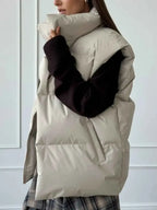 Zip Up Turtleneck Vest in beige polyester with quilted pattern and puffy padded design, worn over black sweater