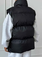 Black quilted Zip Up Turtleneck Vest with padded polyester material and high collar detail, shown from back view