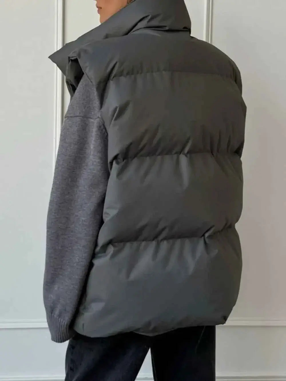 Zip Up Turtleneck Vest in dark gray polyester with padded design and high collar, worn over a gray sweater